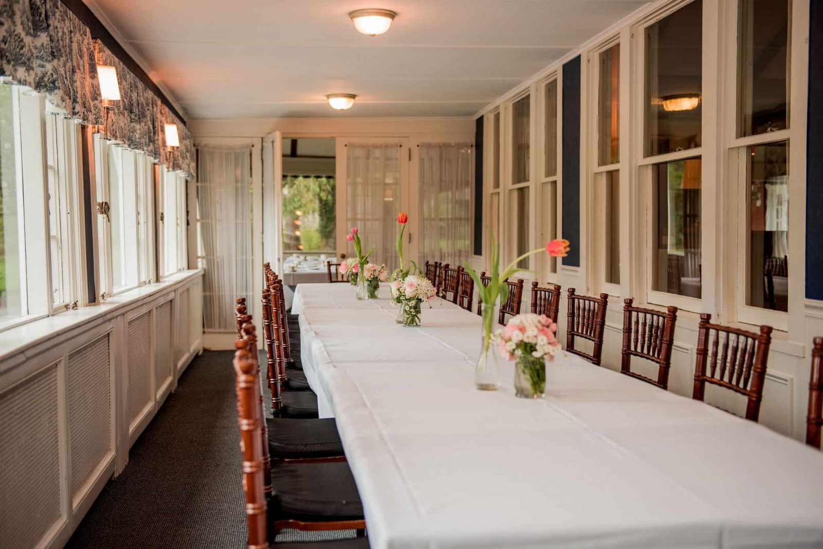 A long dining table stretches out in the porches