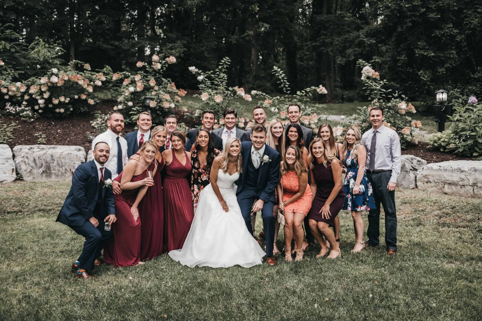 A wedding party poses for a group photo in the Grove at Sringside